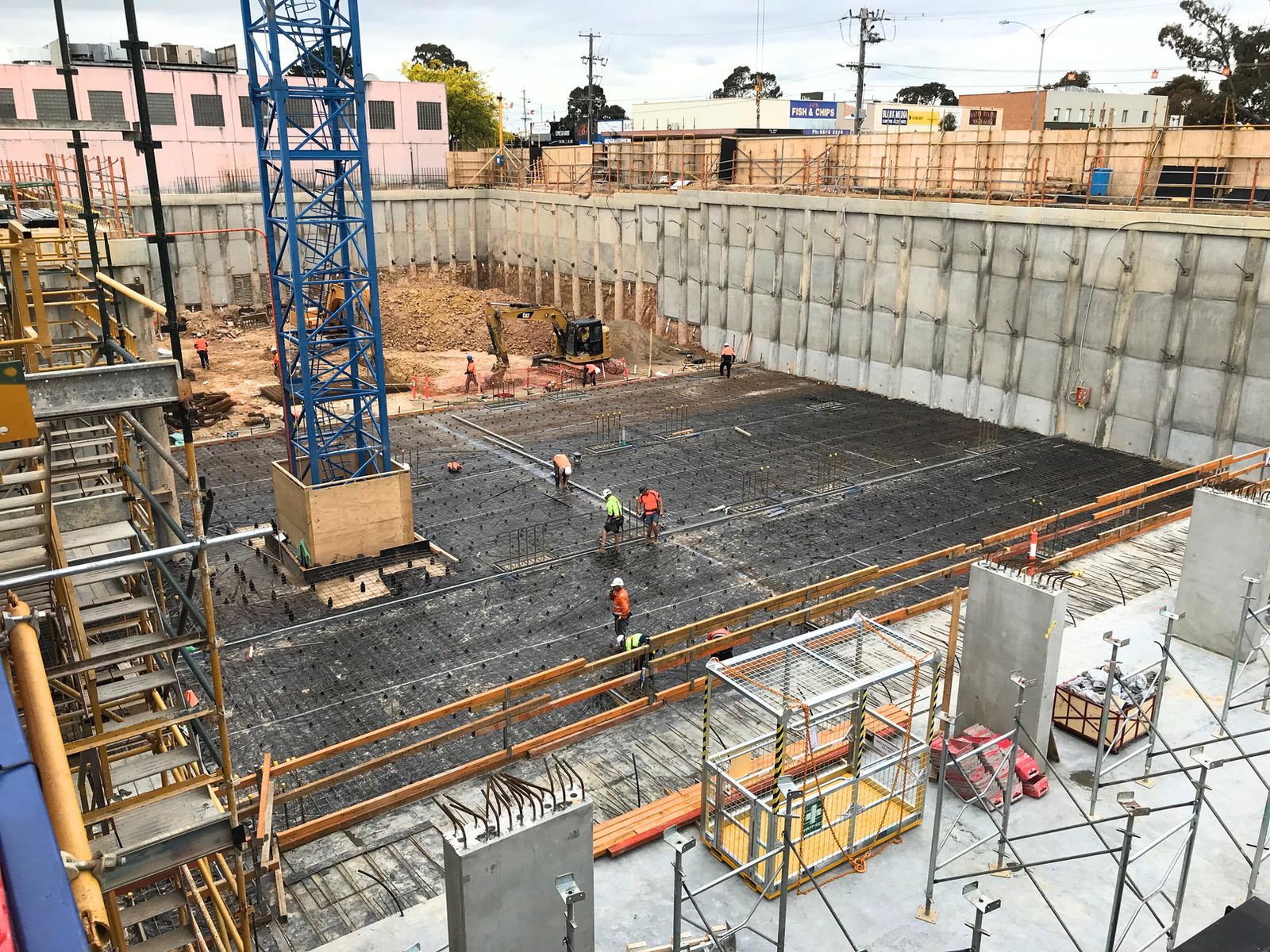 Crew laying reinforcement across a basement slab