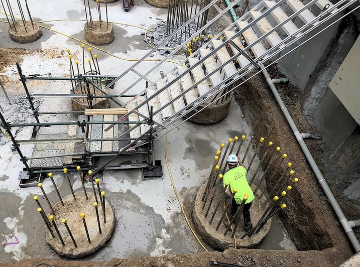 Worker among pile cages and starter bars
