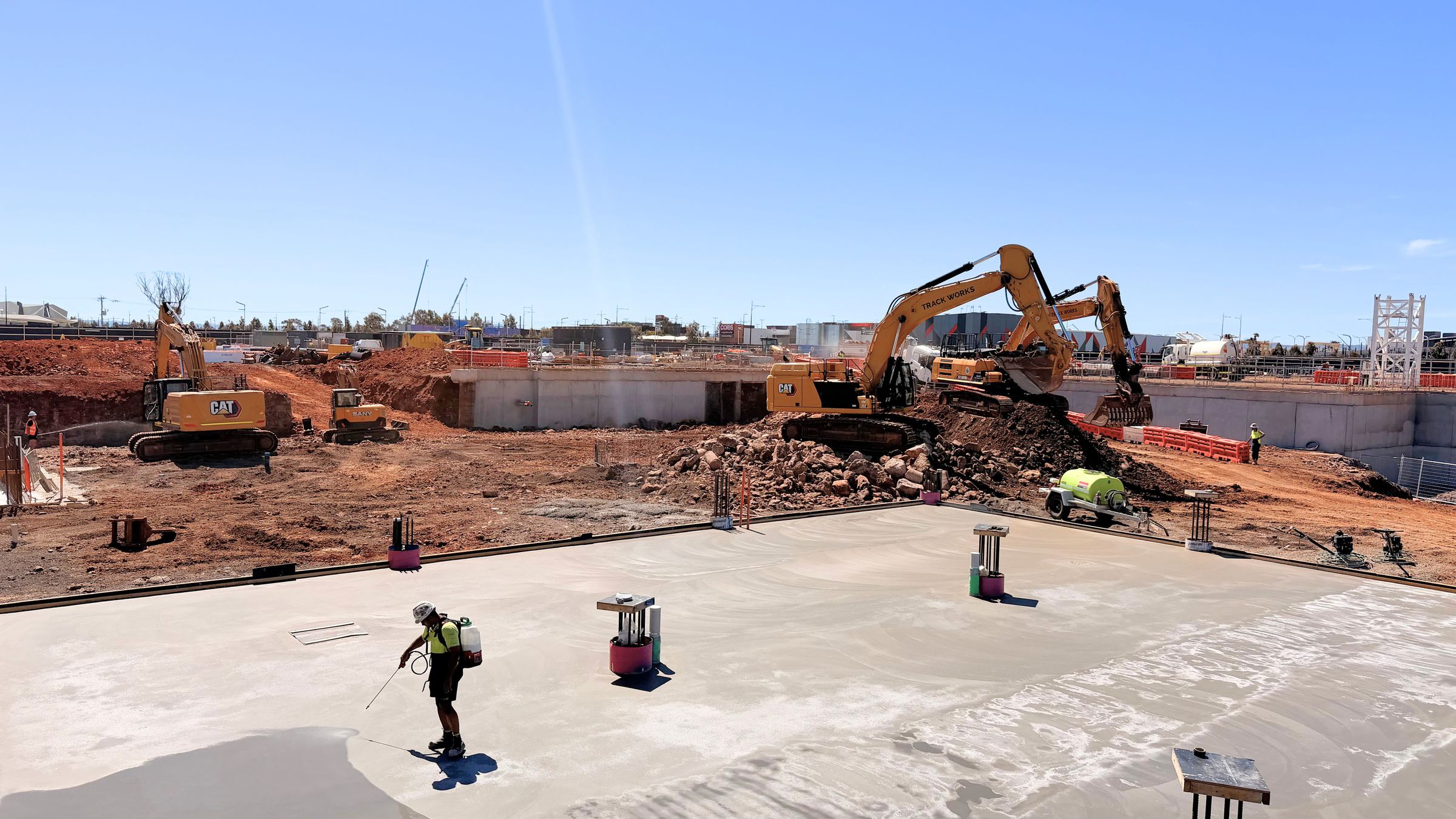 Track Works excavators working beside a freshly poured basement slab